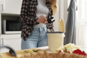 Une femme en train de remplir son Bokashi 